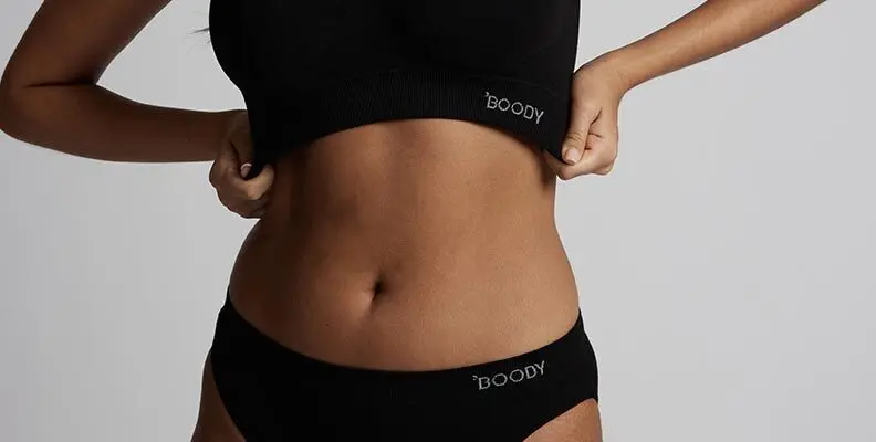 Person wearing black Boody underwear set, showing midriff.