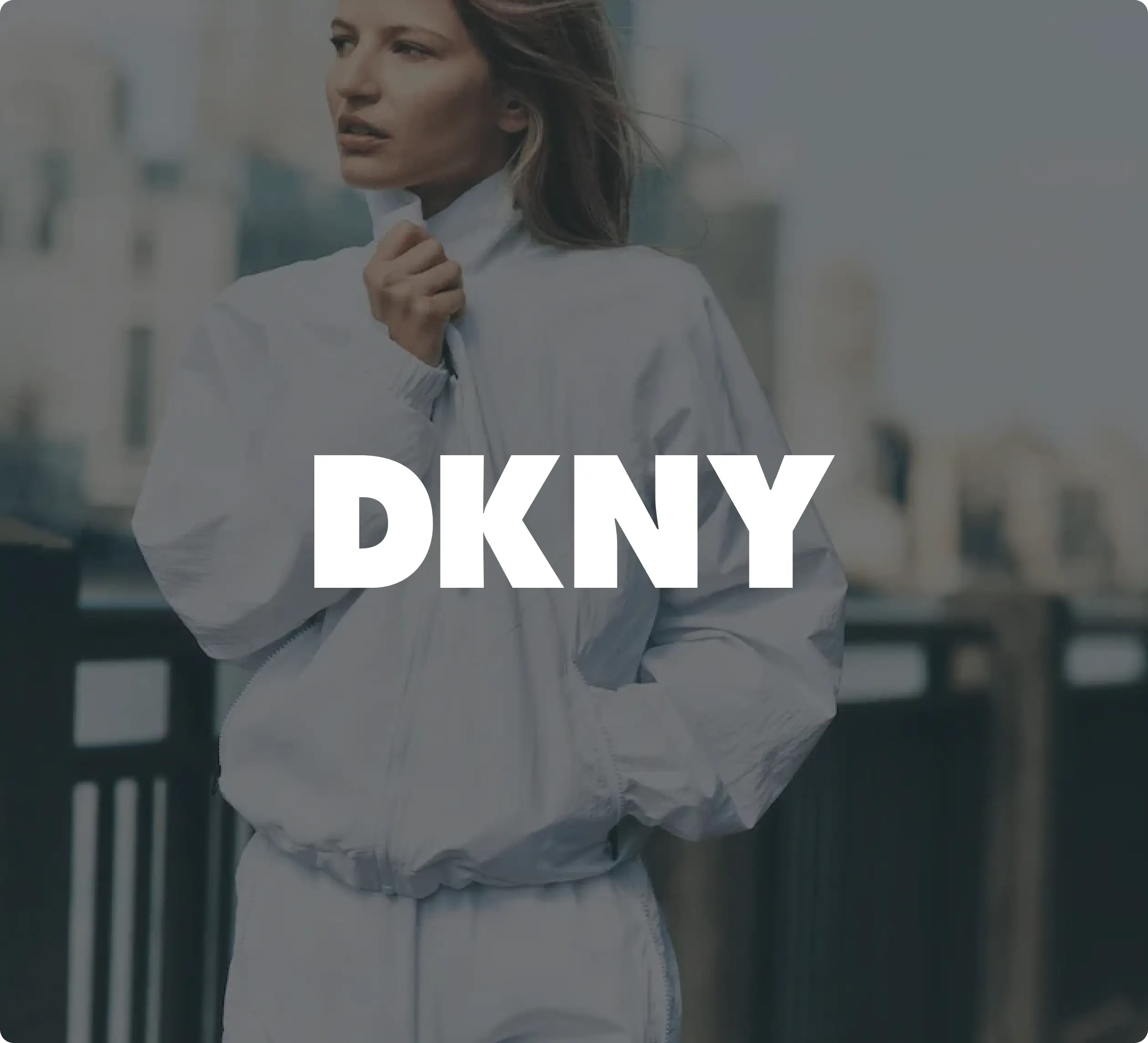 Eine Person trägt eine weiße Jacke. Darüber steht: „DKNY“.