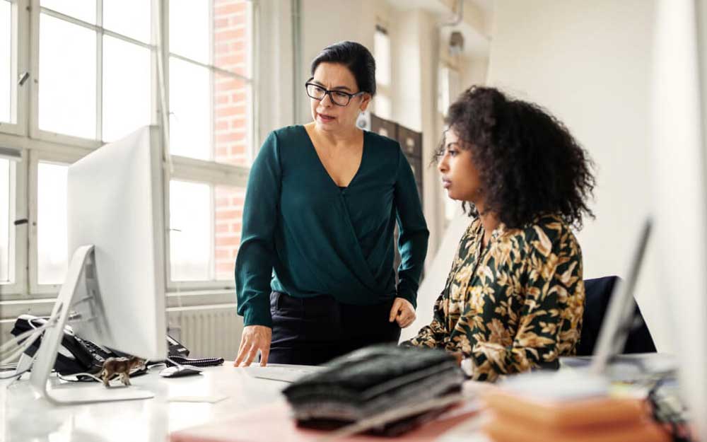 Deux femmes travaillant ensemble devant un iMac