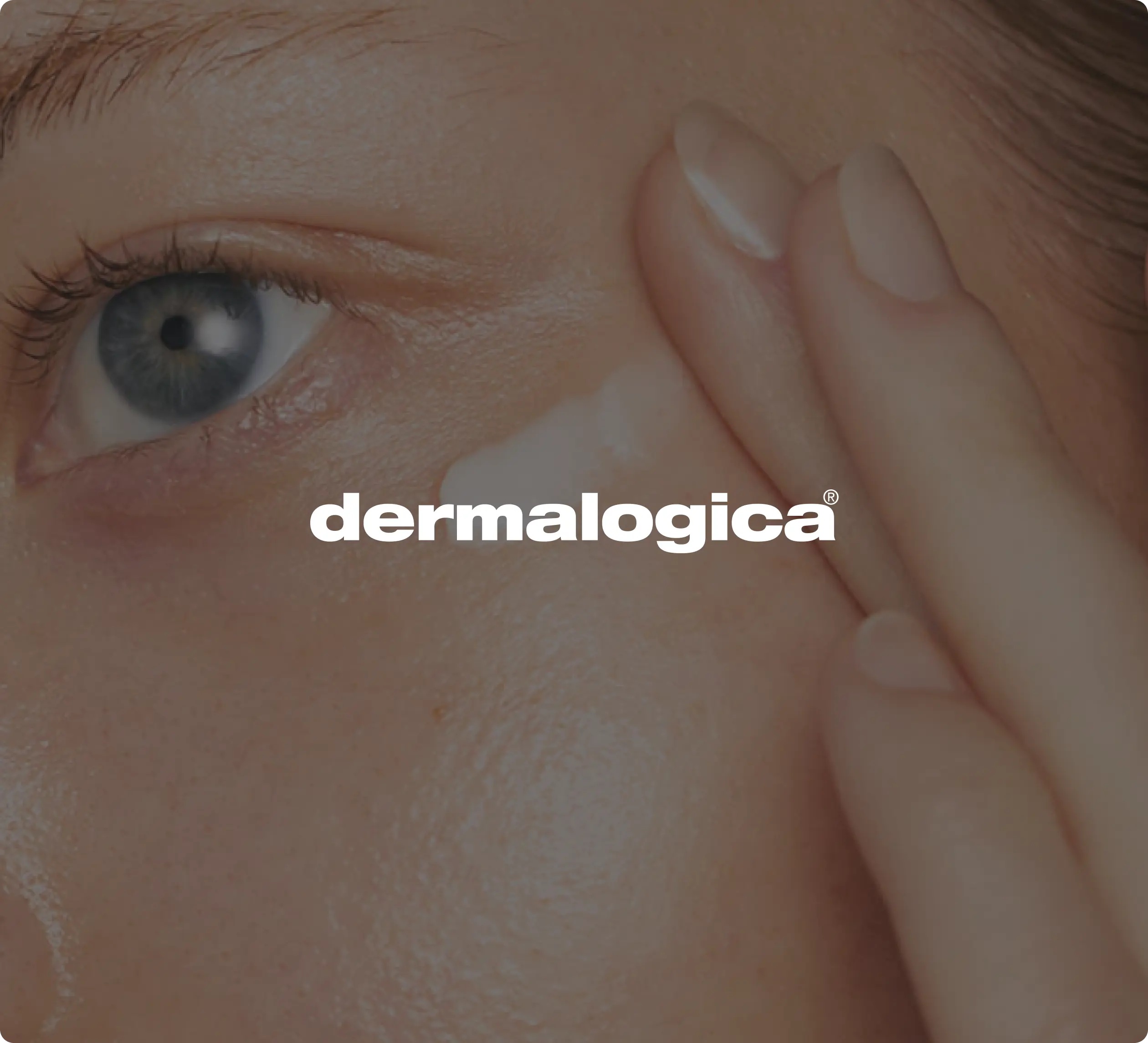 Gros plan d’une personne appliquant de la crème autour de son œil, avec le texte « dermalogica »