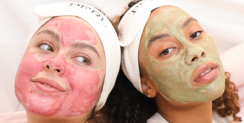 Two women pampering themselves, wearing Perl Cosmetics clay face masks