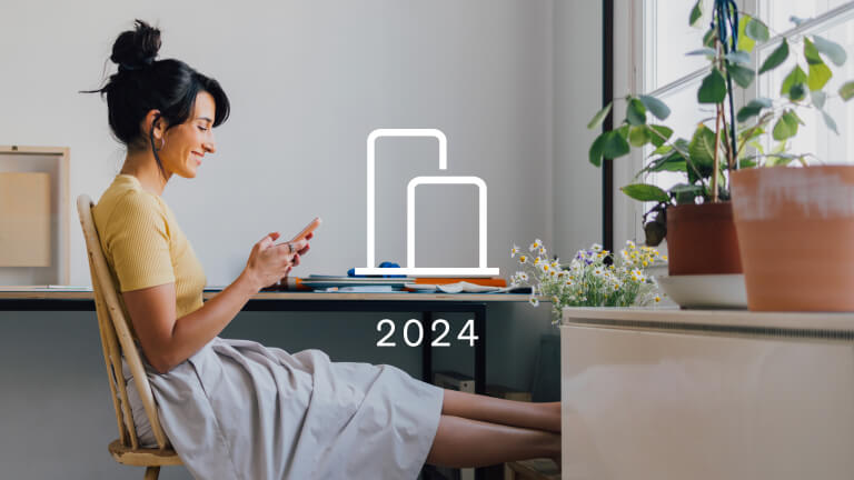 A woman looks at her smartphone. Overtop of the photograph is an icon of a bar graph representing Klaviyo benchmarks. The year 2024 is below the icon.