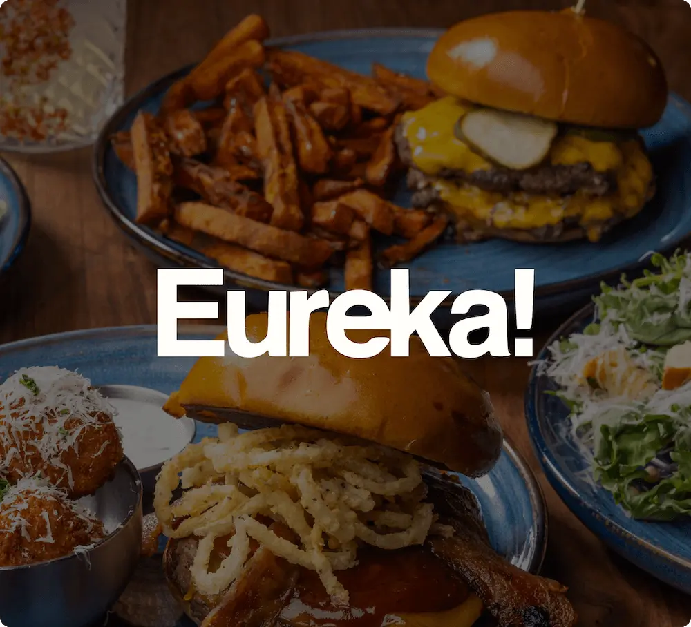 Burgers, fries, and salad on plates with "Eureka!" text overlay.