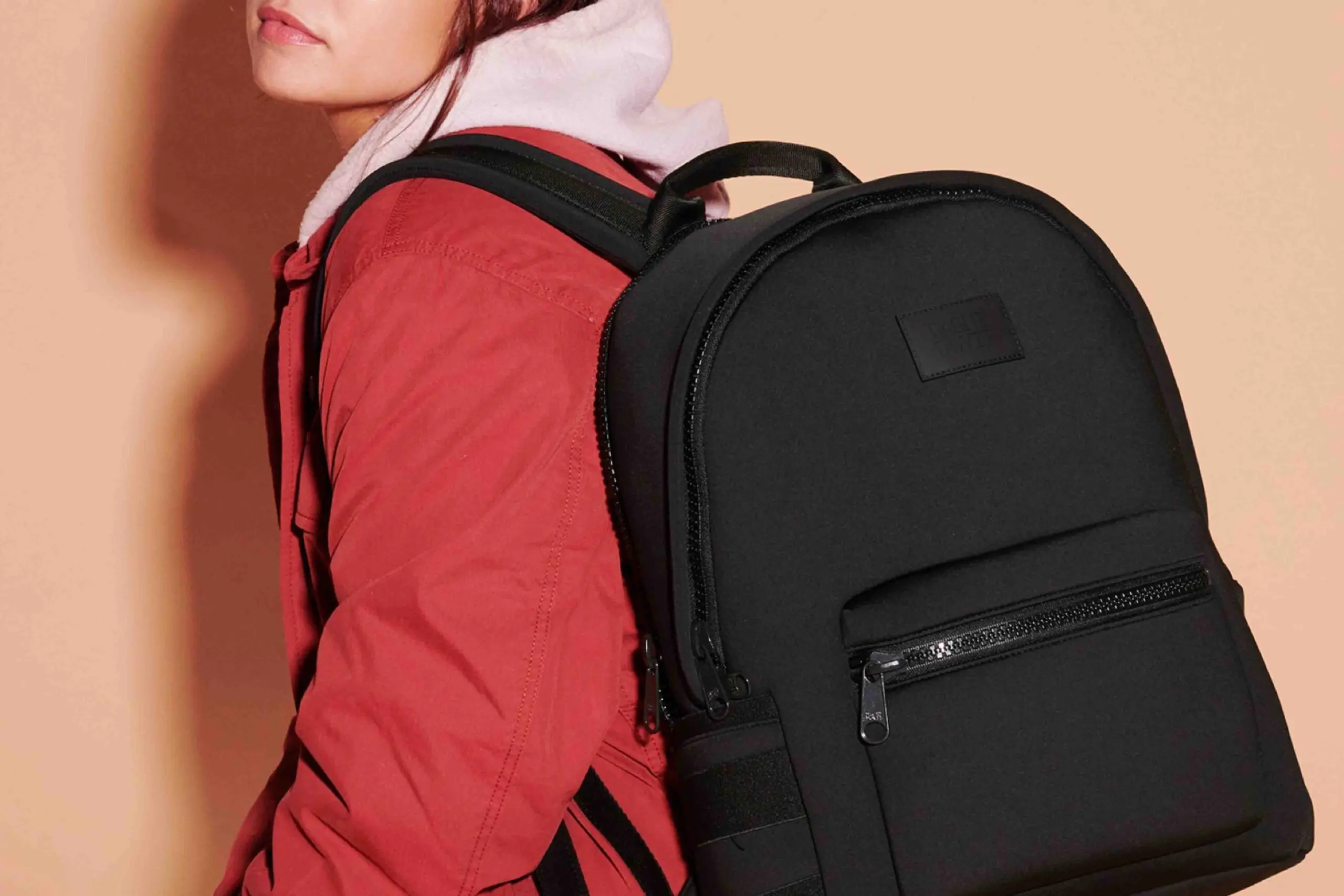 an image of a person with a Dagne Dover black backpack slung over one shoulder