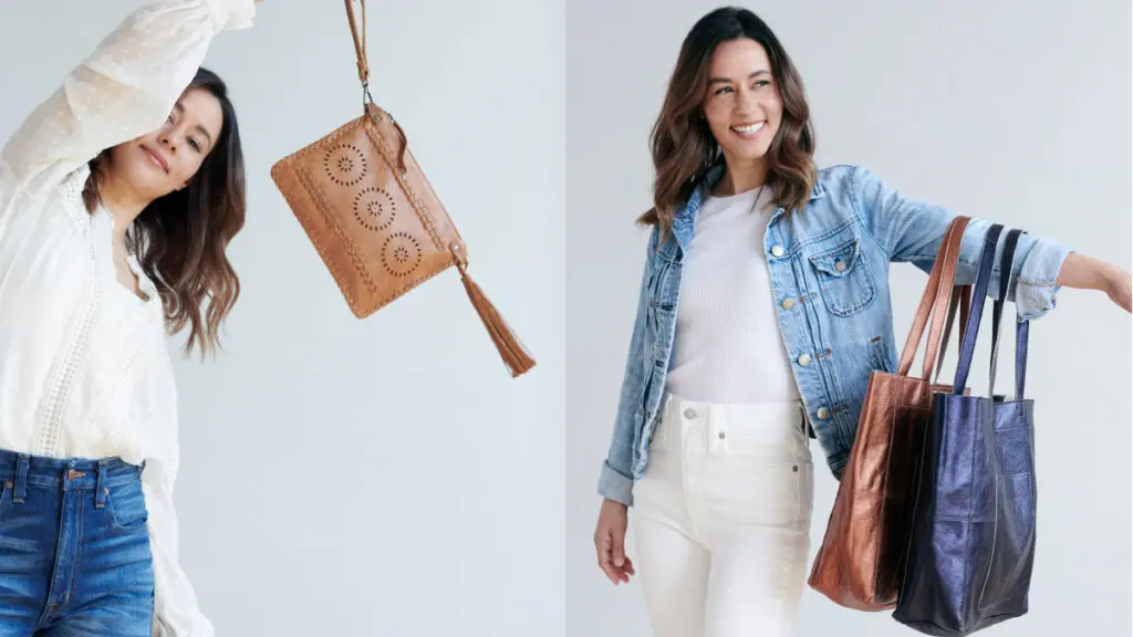 Two women standing side by side holding purses.
