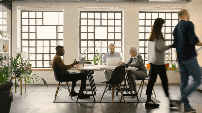 Office co-workers sitting around a table working