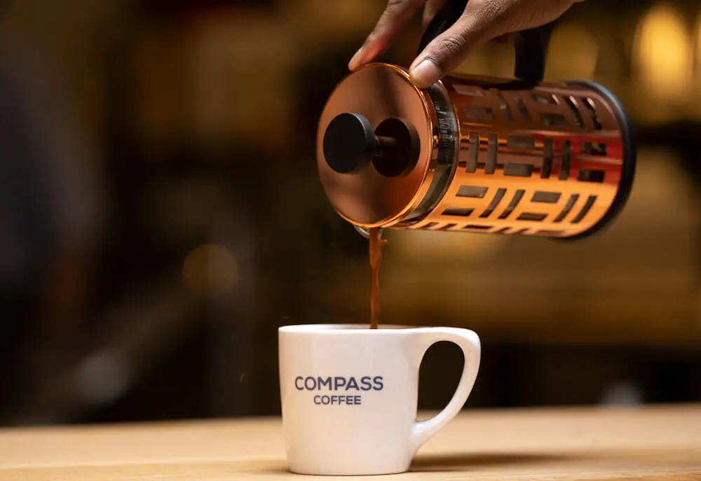 french press pouring coffee into a cup