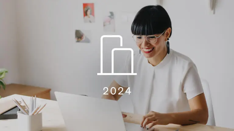 A woman looks at her laptop. Overtop of the photograph is an icon of a bar graph representing Klaviyo benchmarks. The year 2024 is below the icon.